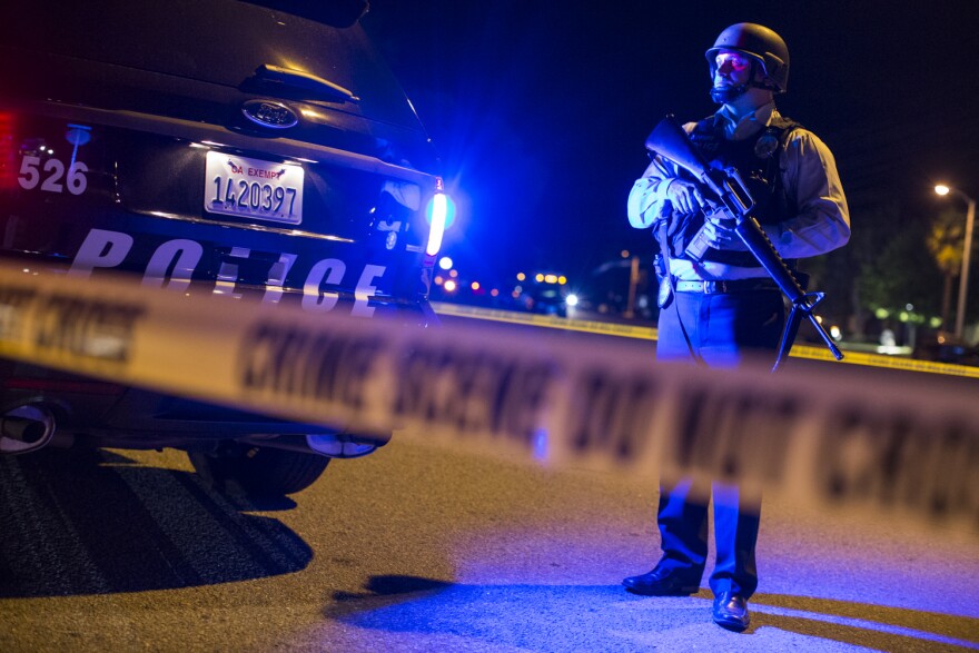 Redlands Police stand on Center Street near Pine Avenue on Wednesday night, Dec. 2, 2015 as authorities serve a search warrant following a mass shooting inside the the Inland Regional Center in San Bernardino on Wednesday, Dec. 2, 2015.