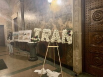 Iran is spelled out in capital letters with white flowers on a wooden easel in a hallway of St. Andrew Church in Pasadena. 