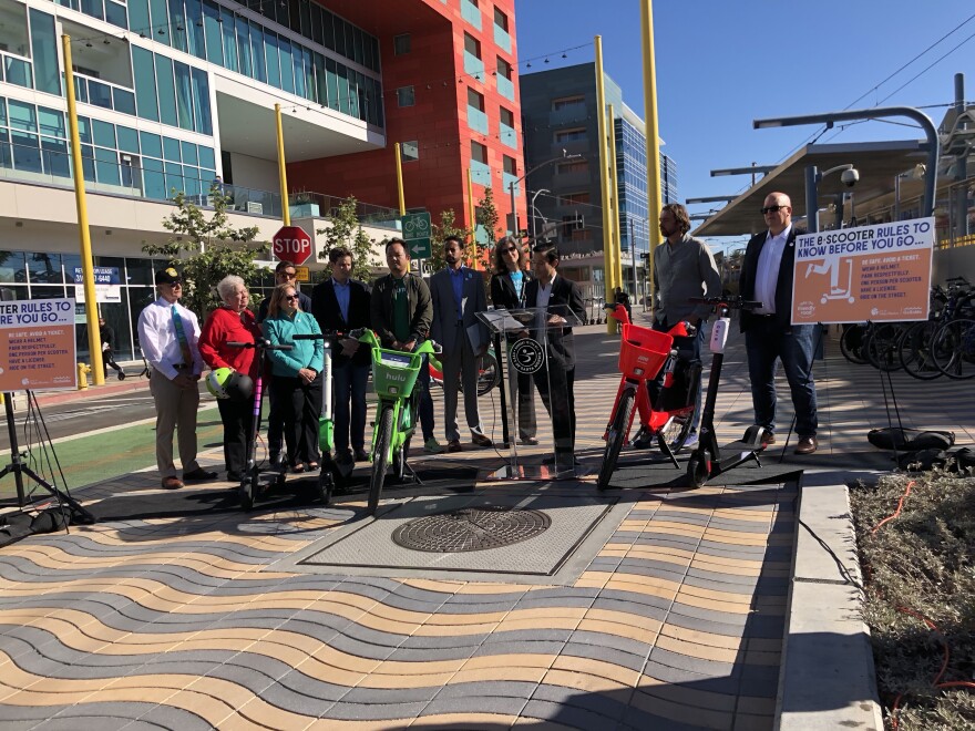 Company leaders stand with their ride share devices during the news conference.
