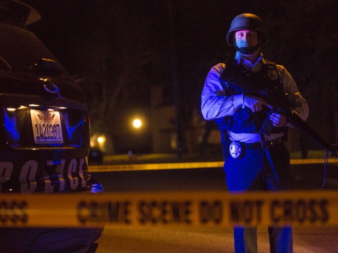 Redlands Police stand on Center Street near Pine Avenue on Wednesday night, Dec. 2, 2015 as authorities serve a search warrant following a mass shooting inside the the Inland Regional Center in San Bernardino on Wednesday, Dec. 2, 2015.