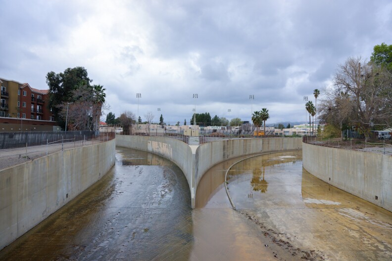 A picture of the LA River's concrete bed with water running through the channel on the left.