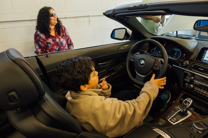 Lizzie Lopez and son check out a car at the opening of the BMW MSTEP at Marine Corps Base Camp Pendleton.