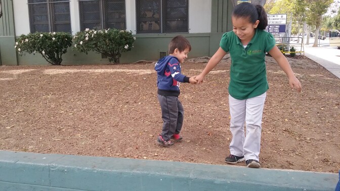 Siblings Alejandro, 3, and Emily, 7, often play on the outside lawn at Lorena Street School where Emily attends a Charter school. The pair live in an apartment with their parents so this is a play spot for them in the neighborhood. The Boyle Heights school is one of several that tested high for lead and the state is still deciding what to do about it.
