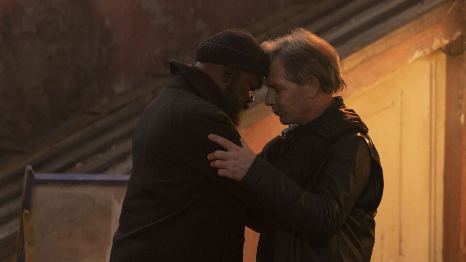 Photo of two men holding each other.