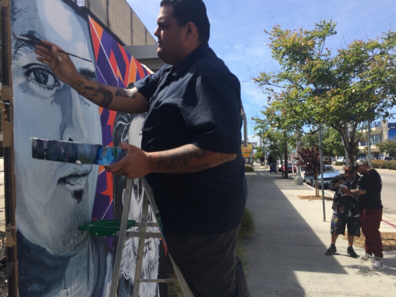 Ray Martinez works on a mural on Van Nuys Blvd just outside Pacoima City Hall. The effort is part of the anti-gang work overseen by artist Manny Velazquez.