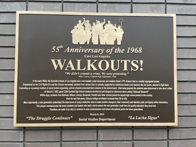 A brown and gold frame plaque with a description of the East L.A Walkouts. 