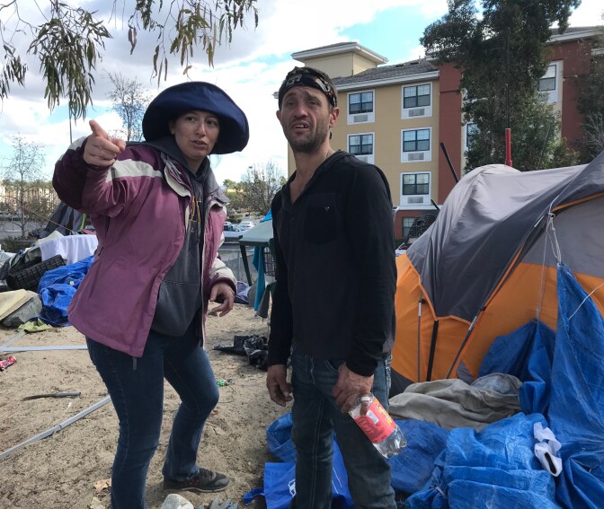 Brooke Meitzer, a lawyer for the homeless, urges a riverbed resident to pack up so he can go spend the night at a motel.
