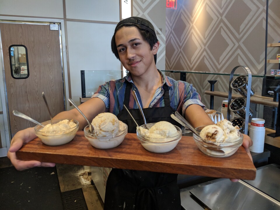 Salt & Straw employee Chuy Hernandez shows off a flight of Thanksgiving ice cream flavors.