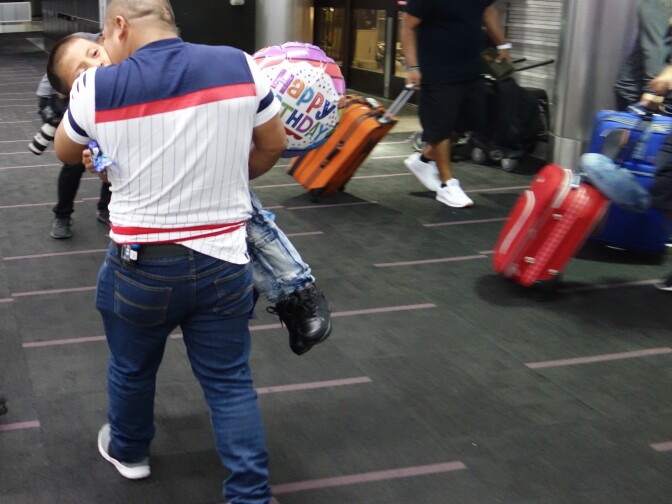                                Hermelindo Che Coc carries his 6-year-old son Jefferson to an airport lounge after the pair were reunited at LAX after a forced separation fo 48 days. Che Coc was held in Texas while his son was taken to a shelter in the Bronx, New York.