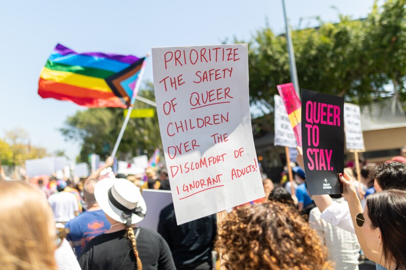 Protesters hold their signs up while marching at the Drag March on Santa Monica Boulevard in West Hollywood.