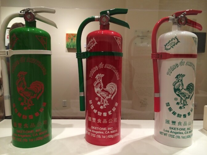 Sket One's "Sketinguish-1 -2, -3." He had fun in creating this art by juxtaposing the hot, fiery aspects of sriracha sauce on fire extinguishers.