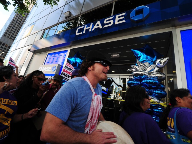 Protestors march through downtown Los Angeles' financial district October 6, 2011 during an anti-Wall Street demonstration.  At least 10 protestors werre arrested after they entered a Bank of America branch and refused to leave. The arrests came at the end of a march of about 500 protestors from labor unions, Occupy LA and other groups who marched passed banks and other financial institutions.