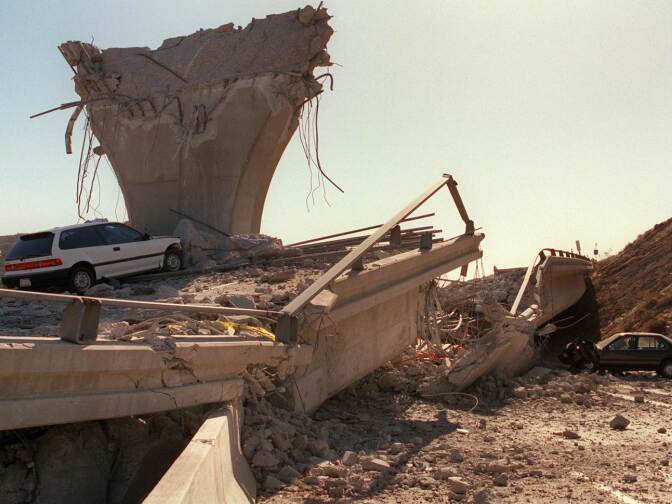Cars lie smashed by the collapsed Interstate 5 connector few hours after Northridge earthquake in Sylmar, California.
