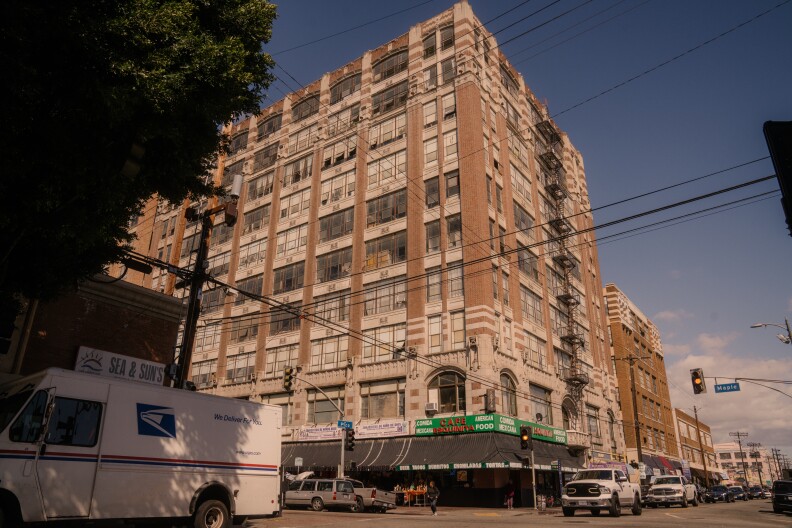 A large multistory brown and white building towers over Downtown L.A.'s Fashion District.
