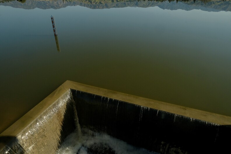 An image from above of water spilling over concrete barriers. 