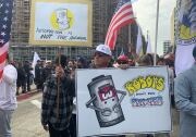 A port worker holds up signs that protest automation in place of humans.