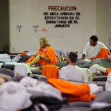 Inmates at Chino State Prison, which houses 5500 inmates, crowd around double and triple bunk beds in a gymnasium that was modified to house 213 prisoners on December 10, 2010 in Chino, California.