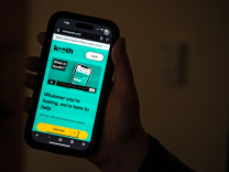 an iphone with a turquiose screen with black text and a yellow "home page" button