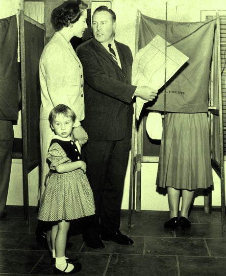 Congressman Patrick J. Hillings and his wife, Phyllis, accompanied by their daughter, Jennifer Ann, cast their votes at their neighborhood polling place in Arcadia on November 4, 1958. He is a Republican candidate for Attorney General. 
