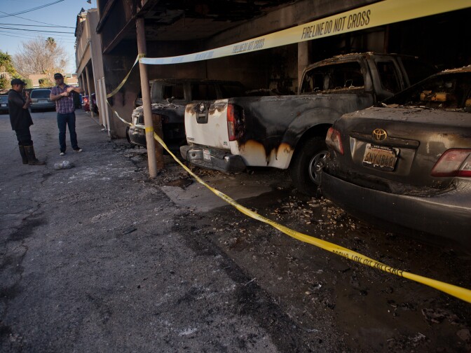 A North Hollywood resident speaks with an officer from the Los Angeles Fire Department task force assigned to investigate the largest arson outbreak in the city since the 1992 riots.