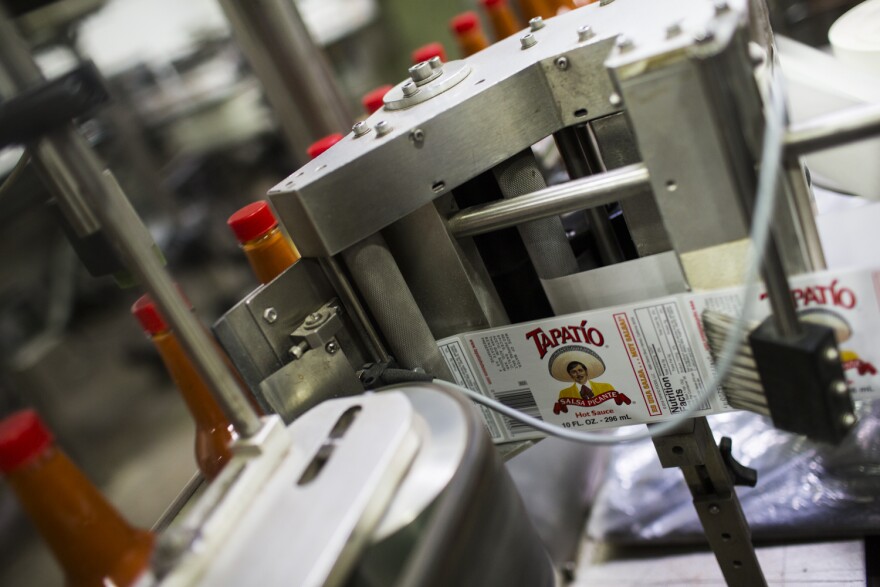 Labels are put on containers of hot sauce at Tapatio Foods in Vernon on Thursday morning, Jan. 14, 2016.