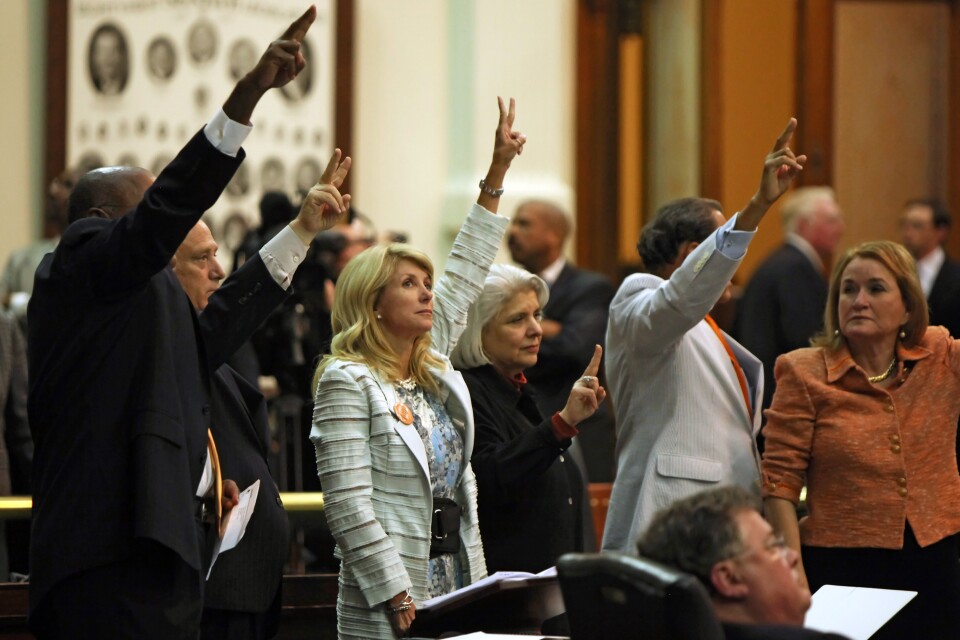 AUSTIN, TX - JUNE 25: State Sen. Wendy Davis (D-Ft. Worth) (3L) holds up two fingers against the anti-abortion bill SB5, which was up for a vote on the last day of the legislative special session June 25, 2013 in Austin, Texas. A combination of Sen. Davis' 13-hour filibuster and protests by reproductive rights advocates helped to ultimately defeat the controversial abortion legislation at midnight. (Photo by Erich Schlegel/Getty Images)