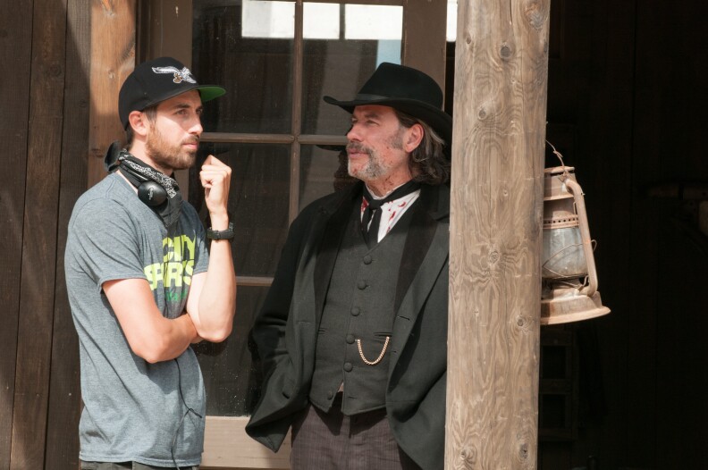 Director Ti West and John Travolta on the set of "In a Valley of Violence."