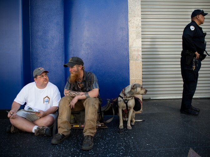 David Foyer conducts the Homeless Count survey outside of McDonald's in Hollywood, Calif. while police clear out  homeless youths loitering outside the business.