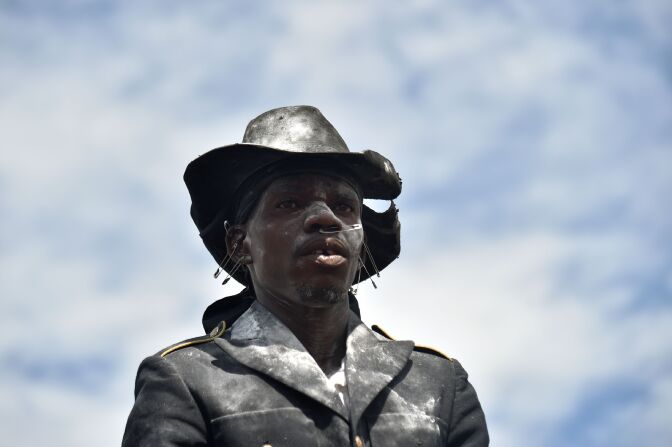 A devotee pretending to be the spirit known as a Gede looks on with clothes pins piercing his skin during a ceremony honoring the Haitian voodoo spirits of Baron Samdi and Gede on the Day of the Dead in the National Cemetery in Port-au-Prince, Haiti on November 1, 2016.
