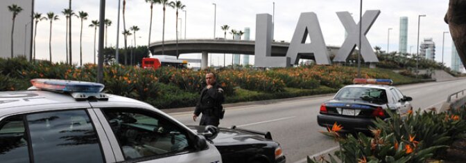 A police officer walks to his patrol car at a security checkpoint near the entrance to Los Angeles International Airport on December 26, 2009.
