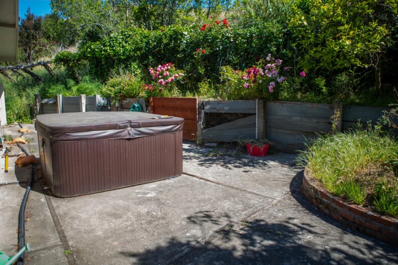 A backyard with a brown jacuzzi.