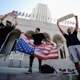 LOS ANGELES, CA - OCTOBER 01:  Protesters hold signs after a march to Los Angeles City Hall during the "Occupy Los Angeles" demonstration in solidarity with the ongoing "Occupy Wall Street" protest in New York City on October 1, 2011 in Los Angeles, California. The protesters slogan, "We are the 99 percent," calls attention to the fact that marchers are not part of the one percent of Americans who hold a vast portion of the nation's wealth.  (Photo by Kevork Djansezian/Getty Images)