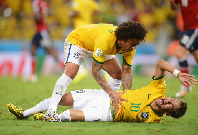 Neymar of Brazil lies injured while Marcelo of Brazil shows concern during the 2014 FIFA World Cup Brazil Quarter Final match between Brazil and Colombia at Estadio Castelao on July 4, 2014 in Fortaleza, Brazil.   