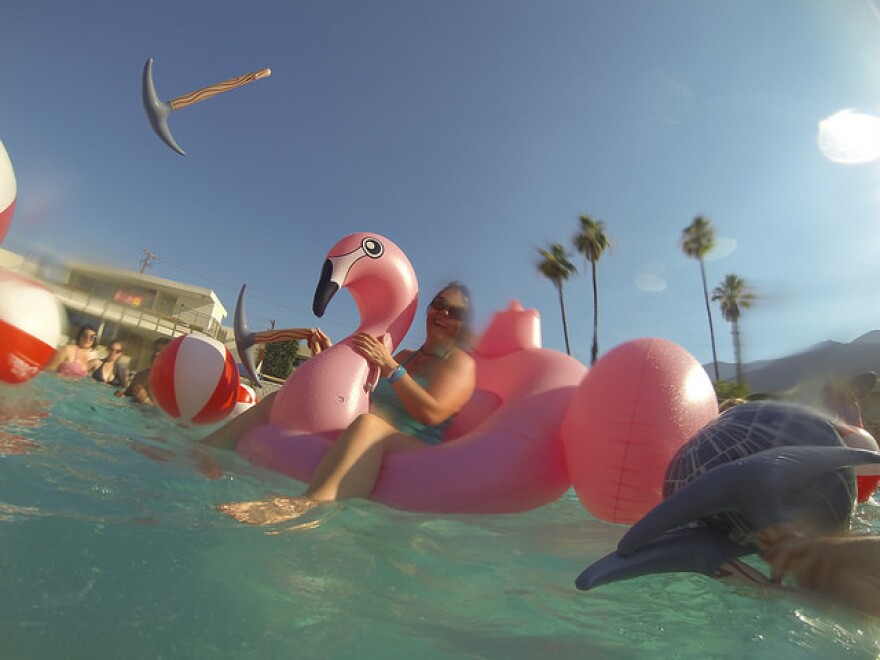 A woman rides a pink swan floatie in the pool of the Ace Hotel in Palm Springs.