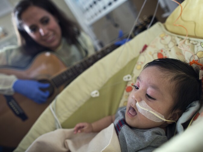 Tacy Pillow, a music therapist, plays a lullaby for Araceli Viveros' 3-month-old son in the Newborn and Infant Critical Care Unit on Feb. 20, 2015. For the first two months after her son was born, Vivieros slept at the hospital every night.