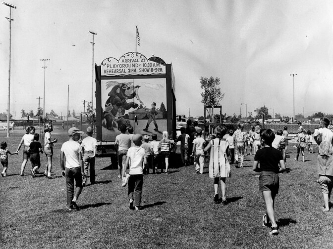Children follow a truck as it drives into position at Granada Hills Playground to set up the 1964 Combined Traveling Circus and Kiddie Carnival. Photo dated: July 4, 1964. 