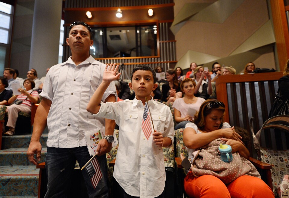 U.S. citizenship candidate Ricardo Barrera, 8, takes the oath of citizenship as his father Ricardo Barrera (L) mother Reina Barrera and his sister Ashley, 1, look on during a naturalization ceremony at the Los Angeles Central Library on September 19, 2012 in Los Angeles, California. Fifty local children participated in the citizenship ceremony. In recognition of Constitution Day and Citizenship Day, over 32,000 new citizens will be welcomed by U.S. Citizenship and Immigration Services from September 14 to September 22.  