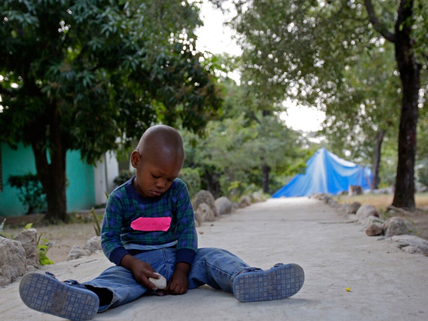 A young boy plays with stones earlier this week at an orphanage in Port-au-Prince. He was among the group of 33 Haitian children that 10 American church workers tried to take across the border into the Dominican Republic.