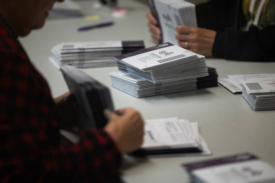 a stack of voting ballots on the top of a table
