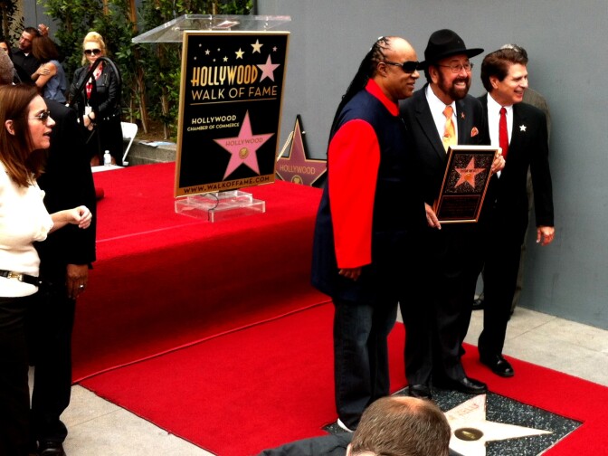 KRTH's Shotgun Tom Kelly, center, in hat, poses with Stevie Wonder over Kelly's new star on the Hollywood Walk of Fame. 4/30/2013