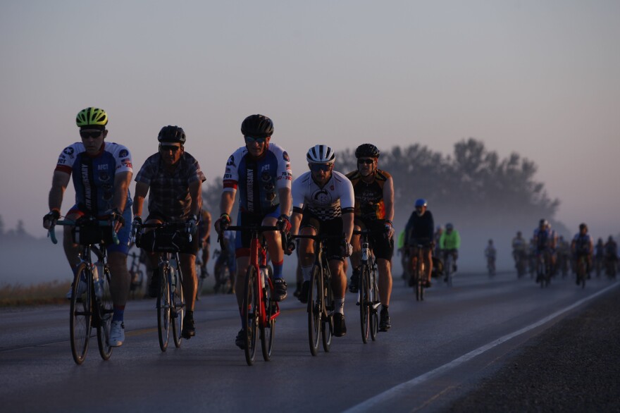A group pf riders makes their way through the early morning fog Wednesday, July 28, as they make their way out of Emmetsburg, Iowa, on Day 4 of RAGBRAI. Riders travelled more than 100 miles that day, completing a "century ride" in honor of one of the ride's late co-founders, John Karras, who died late last year.