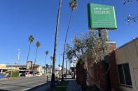 A green sign atop a one-story building reads "BRIER OAK ON SUNSET"