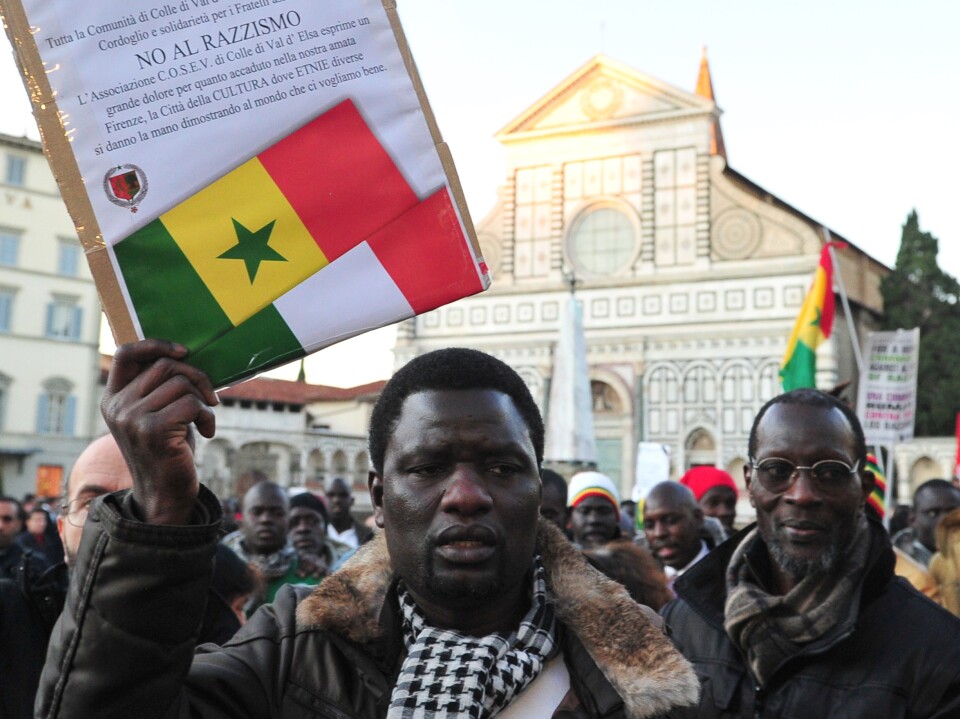 A demonstrator holds a placard reading "No to racism" in front of Santa Maria Novella church in Florence, Italy, during a Dec. 17, 2010, anti-racism march in memory of two Senegalese men who were killed four days earlier by a far-right Italian.