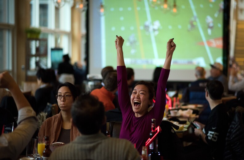 Fans cheer as they watch a live broadcast of Super Bowl XLIX between the New England Patriots and Seattle Seahawks, at a restaurant in Shanghai on February 2, 2015. A study released on January 28 by sports marketing research firm Repucom found that since 2013 interest in the NFL among the Chinese population has jumped from 1.7 percent to 7.9 percent.  AFP PHOTO / JOHANNES EISELE        (Photo credit should read JOHANNES EISELE/AFP/Getty Images)