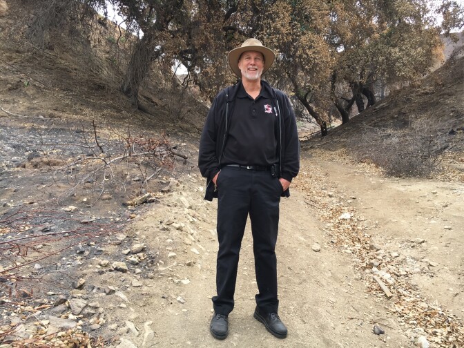 Mike Custer, facilities director at the 1,100-student Village Christian School stands in terrain burned by the Labor Day weekend La Tuna Fire. It came very close to the campus