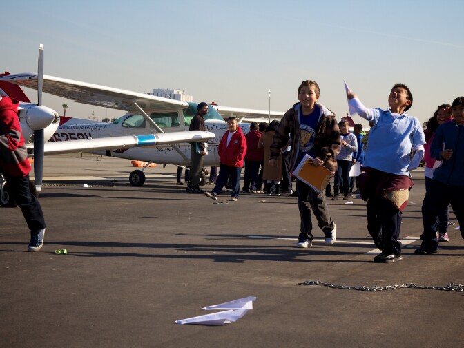 After the competition, several kids kept trying to outdo each others' paper airplanes.