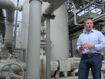 In this April 25, 2014 photo, Joshua Haggmark, interim resources manager for Santa Barbara, Calif., stands next to a desalination plant, which removes salt from ocean water, in Santa Barbara, Calif.  The city is considering restarting the plant as California withers in a drought.
