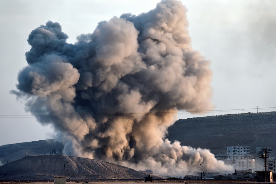 Smoke rises from the impact of an airstrike next to the hill where Islamic State (IS) militants had placed their flag in the Syrian town of Ain al-Arab, known as Kobane by the Kurds, seen from the Turkish-Syrian border in the southeastern village of Mursitpinar, Sanliurfa province, on October 8, 2014. The Pentagon warned on October 8, 2014 US air power on its own could not prevent Islamic State jihadists from capturing the Syrian border town of Kobane, even as US warplanes kept up bombing raids in the area.