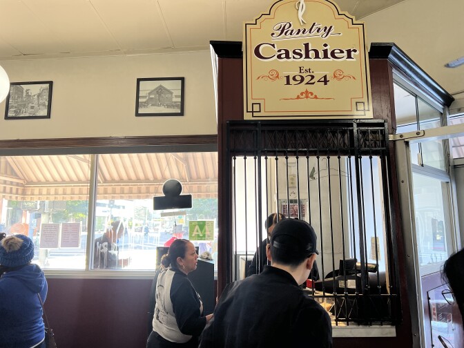 Customers pay at a cashier inside a restaurant