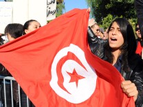 File: A Tunisian woman holds a flag of Tunisia during a demonstration in front of the assembly on December 3, 2011 in Tunis.